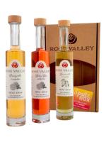 3 Flaschen Rose Valley Likör vor der Verpackung stehend
